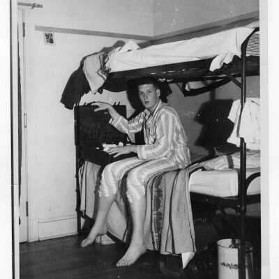 Student from Barry Hall in pajamas in dormitory room.