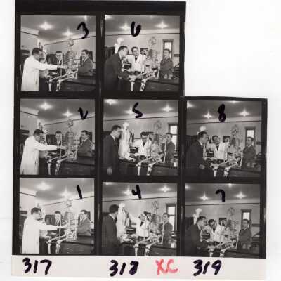 Views of faculty member, Francis J. MacEntee, S.J, of Biology Department looking at skeleton in science laboratory with two students, April 1964.