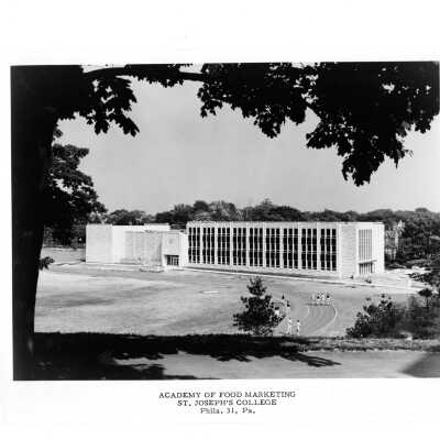 View of Finnesey Field and Villiger (later Post) Academy of Food Marketing with people running on track.