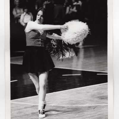 Woman cheerleader at basketball game.