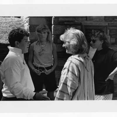 Four women students standing in group outside talking.