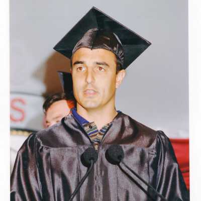 Graduate student, possibly Edward Mancinelli or Joh Versaggi, speaking to audience during 1999 graduation/commencement.