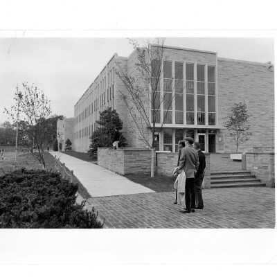 Exterior view of side and front of Villiger (later Post) Academy of Food Marketing with people walking.