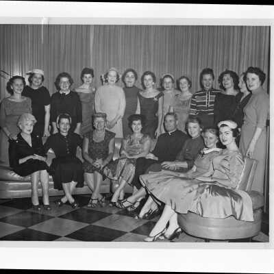 Michael Smith, S.J., with wives of alumni association members planning a supper dance, c. 1960.