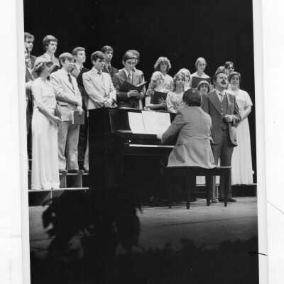 Students in Glee Club practicing on stage.