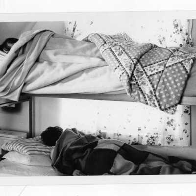 Students sleeping in bunk beds in dormitory room.