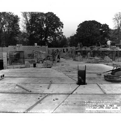 View of early construction of McShain Hall with workmen.