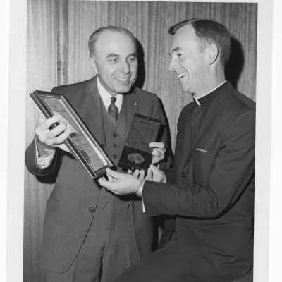 Shaffrey award recipient, Dr. Peter A. Herbut, showing medal and certificate to Terrence Toland, S.J., April 19, 1970.