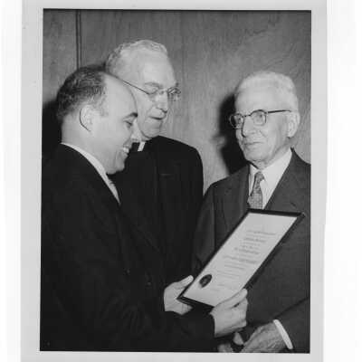 Dr. J. Parsons Schaeffer showing Shaffrey award medal to J. Joseph Bluett, S.J., and Dr. Buono, 1959.