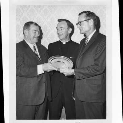 Romanus Buckley receiving Law Alumni Award with Terrence Toland, S.J., and Camden Mayor Joseph Nardi (?) watching, November 10, 1970.