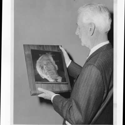 Dr. Daniel Dougherty, recipient of 1971 Hogan Alumni Award, holding plaque.