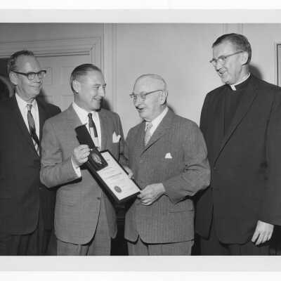Dr. Brogan showing Shaffrey award and medal to Dr. Truman G. Schnabel, Sr., April 21, 1963 with William F. Maloney, S.J. watching.