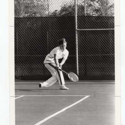 Women's tennis team team member practicing.