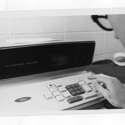 Student using tabletop Friden 132 Electronic Calculator.