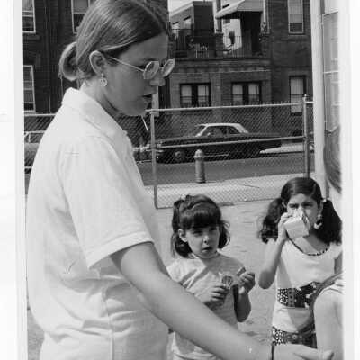 Student with children on playground as part of Mississippi summer project, a community service/outreach program (?)