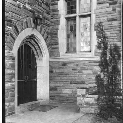 Exterior view of wooden door entrance to Barbelin building off of quadrangle.
