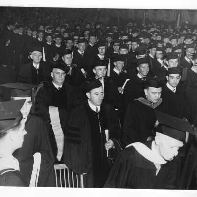 View of honorary degree recipeints and others processing in Field House during 1951 graduation/commencement. Individuals include: Edward G. Jacklin, S.J., Matthew Sullivan, S.J., and G. Bennett, Wm. Green, and J. O'Mahoney.