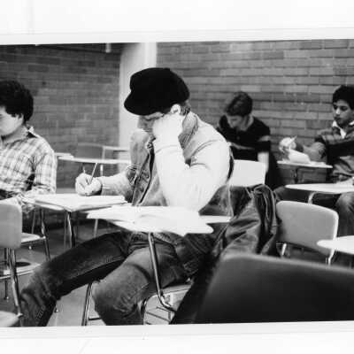 Several students taking exam in classroom.
