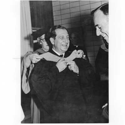 Terence Toland, S.J., with honorary degree recipient, Fred Hechinger during 1970 graduation/commencement. Michael J. Smith, S.J., and Hilda Fell also present in photograph.
