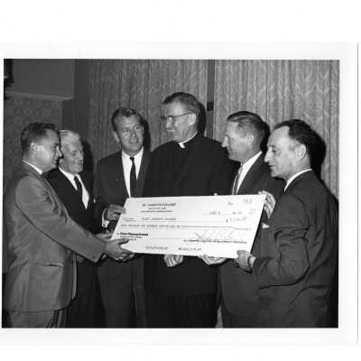 Several alumni from class of 1938 at twenty-fifth reunion, June 8, 1963, and presenting William F. Maloney, S.J. with check for $4,130.00