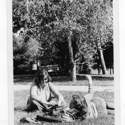 Two women students studying on lawn.