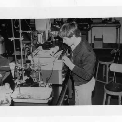 Male student working on experiment in science laboratory.