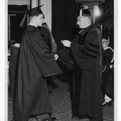 Tropaia exercises during 1955 graduation/commencement with Edward G. Jacklin, S.J., student, and others.