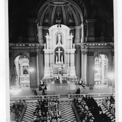 Interior view of Church of the Gesu in Philadelphia at Eighteenth and Stiles Streets with parishioners attending mass.