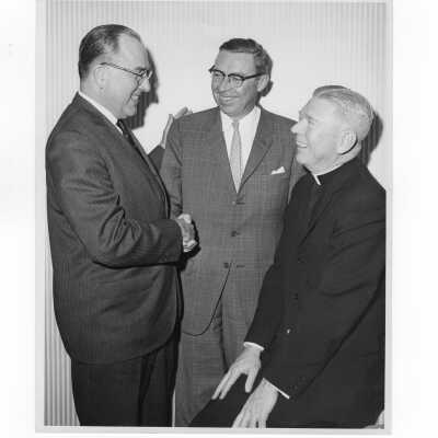 John Clark, Paul E. Kelly, and Lawrence McHugh, S.J., during alumni association Century Club dinner, January 20, 1964, as part of fundraising drive.