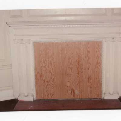 Interior view of boarded fireplace in Wolfington Center (formerly Gest Estate, Neumann Hall).