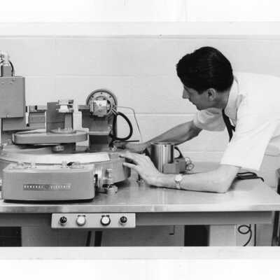 Professor adjusting equipment in science laboratory.