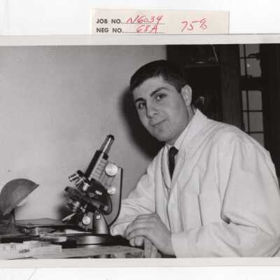 Chemistry student with microscope in science laboratory, c. 1965.