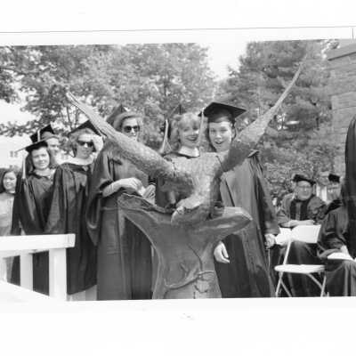 Graduates processing to stage behind sculpture of a hawk to receive diploma during 1993 graduation/commencement.