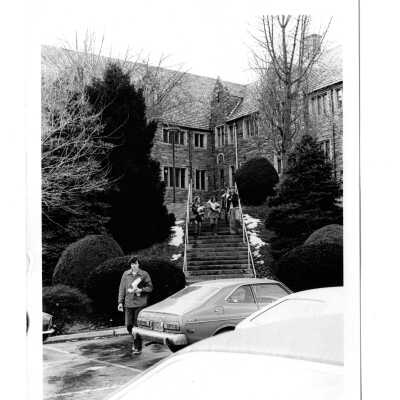 View of students descending steps to parking lot with Barbelin building in background.