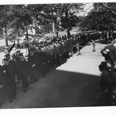 Students in cap and gown processing into cathedral for Baccalaureate service as part of 1950 graduation/commencement.