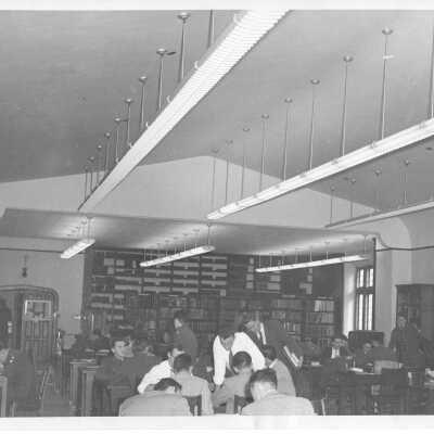 Interior view of library in Barbelin building with students studying and talking.