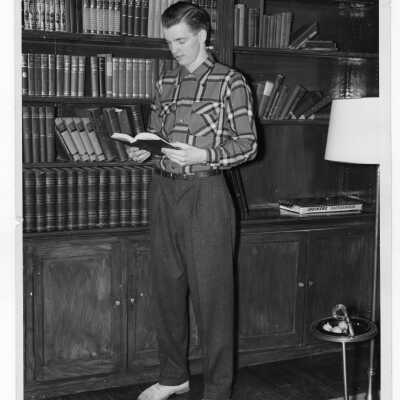 Student of Quirk Hall standing in front of bookshelf.