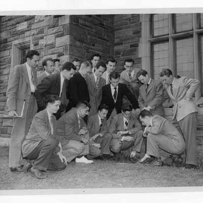 Students participating in ceremonial planting of ivy during Junior Week activities with John J. Long, S.J., President.