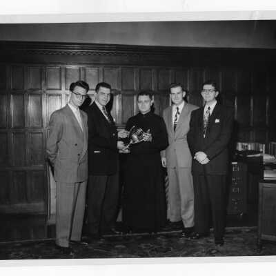 Student members of Villiger Debating Society giving trophy to Edward G. Jacklin, S.J. Students include F. Emmett Fitzpatrick, Thomas Shea, Francis J. Hartman, and Joseph English.