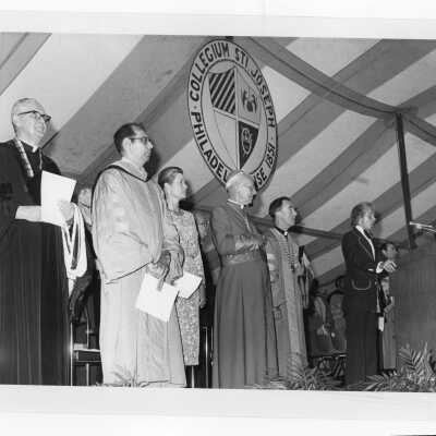 Princess Grace of Monaco, Cardinal John Krol, Terrence Toland, S.J., Daniel DeLucca, William Maloney, S.J., with individual singing anthem at academic convocation held on Gest Lawn, July 31, 1976, as part of SJC 125th anniversary celebration.