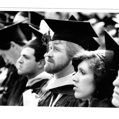 Views of small groups of graduating students during graduation/commencement, c. 1984.