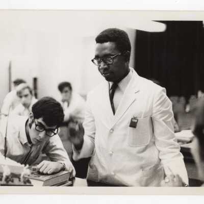 Biology professor, Kodwo J. Abaidoo, working with students in science laboratory, c. 1970.
