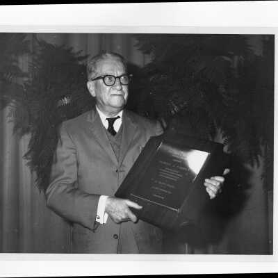 Edward J. O'Reilly holding Hogan Alumni Award plaque, February 1968.