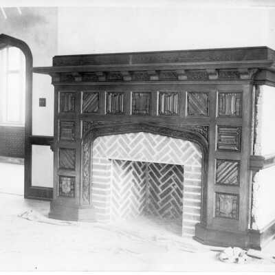 Interior view of a room in Barbelin showing fireplace and ornately carved wooden mantle.