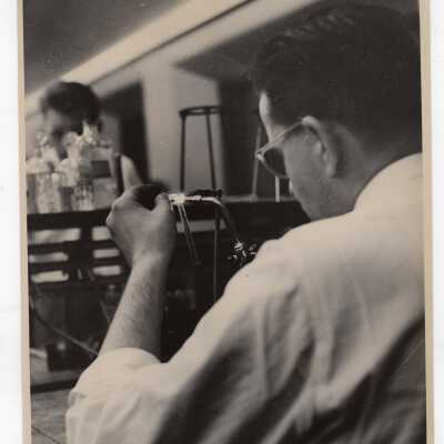 Graduate chemistry student working with blowtorch in science laboratory, c. 1960, possibly in connection with glass blowing.