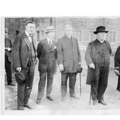 Joseph C. Trainer, architect Francis Ferdinand Durang, Albert G. Brown, S.J., college president, and Dennis Cardinal Dougherty discussing Barbelin building at new college site on City Avenue in Overbrook. Cardinal Dougherty is wearing street clothes.
