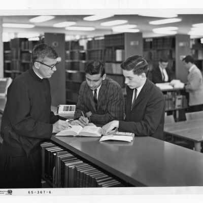 Jerome Coll, S.J., working with two students in Honors Program in Drexel Library, c. 1968.