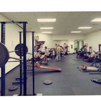 View of exercise room with equipment and students in Sports Complex.