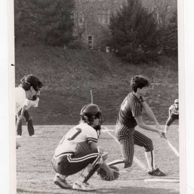 Women's softball game against Lehigh University with Barbelin Hall in background.
