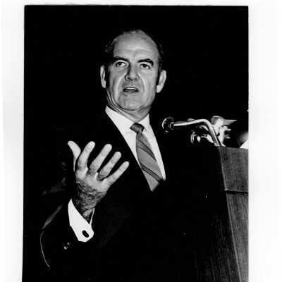 Senator George McGovern delivering speech from podium in Field House, October 2, 1969.